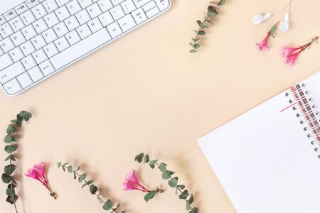 Top view of home office desk with laptop, notebook, headphones, computer mouse and  and eucalyptus and weigela on yellow paper background. 
Flat lay, top view, copy space concept.の写真素材