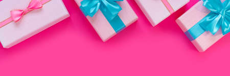 Banner from set of beautiful gift boxes with blue bows on pink background. Holiday sale. Copy space for your text. Flat lay, top view, copy space concept.の写真素材