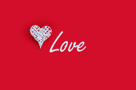 Beautiful heart on red paper background for Valentine's day. Creative greeting card and wooden cubes with text: "love". Flat lay, top view, copy space concept.の写真素材