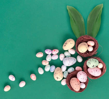 Beautiful Easter card with colorful eggs on paper green background. Flat lay, top view, copy space...