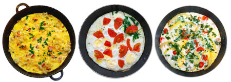 Set of traditional rustic omelette with bacon, pasta and greens on old black frying pan on white isolated background.の写真素材