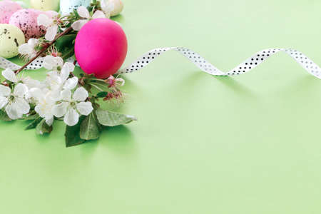 Beautiful Easter card with colorful eggs and cherry branches on paper beige background. Floral greeting card with copyspace for your text.の写真素材