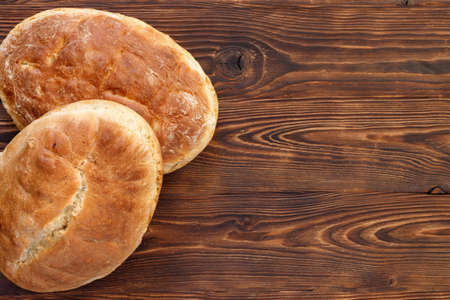 Fresh homemade wheat bread on wooden table. Flat lay, top view, copy space concept.の写真素材