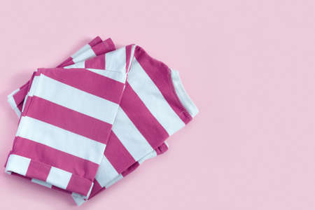 Striped pink T-shirt on paper background. Flat lay Top view with copy space for your textの写真素材