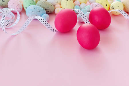 Beautiful Easter card with colorful eggs and ribbon on paper pink background. Flat lay, top view, copy space concept.の写真素材