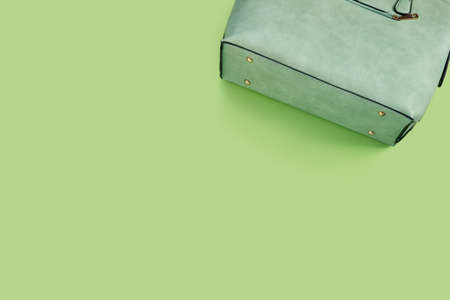 Beautiful fashionable green bag on delicate paper background. Flat lay Top view with copy space for your text.の写真素材