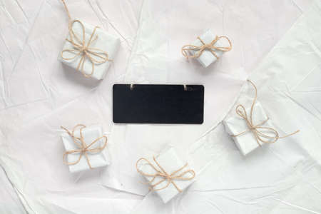 Heap of gift boxes in vintage wrapping paper on pink background. Minimal creative backdrop for holiday. Wooden board with place for text. Flat lay top view with copy space concept.の写真素材