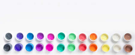 Paints and brushes for painting on white paper background. Flat lay, top view, copy space concept. Creative web banner.の写真素材