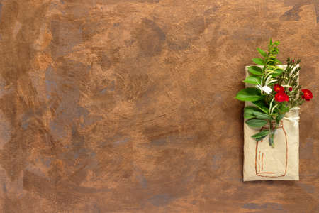 Wrapping paper gift with bouquet of crimson roses, branch of honeysuckle and vase illustration on gold background. Creative holiday present. Flat lay, top view concept with copy space.の写真素材