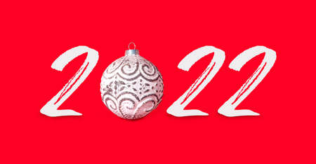 New year holiday card with ball and text 2022 on red paper background. Creative party invitation. Copy space for text. Merry Christmas and Happy New Year!の写真素材