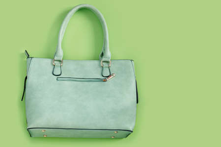 Beautiful fashionable green bag on delicate paper background. Flat lay Top view with copy space for your text.の写真素材