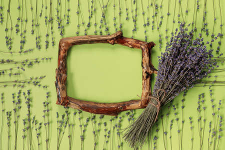 Wooden frames with beautiful bouquet of fragrant lavender in rustic style for gift on green wall. Holiday party decoration. Vintage floral card. interior concept.の写真素材