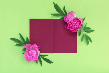 Bouquet of beautiful pink peonies on green paper background. creative spring concept. Festive greeting card. Flat lay, top view with copy space for text.の写真素材