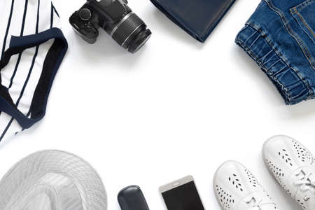 Vacation clothes set with phone and hat on white isolated background. Flat lay, top view, copy space. Minimal celebration conceptの写真素材