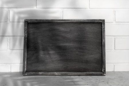 Mockup art of vintage chalkboard background texture with old vintage wooden frame with leaf shadow,...