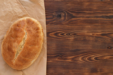Fresh homemade wheat bread on wooden table. Flat lay, top view, copy space concept.