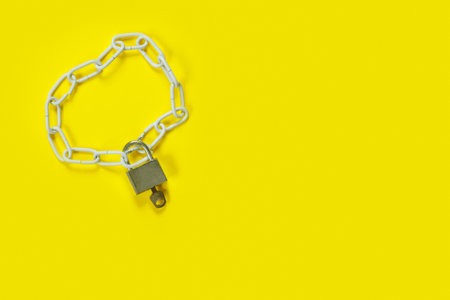 The padlock and chains on yellow background. Flat lay, top view with copy space for text. Banner.の写真素材