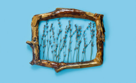 Wooden frames with bouquet of fragrant lavender in rustic style on blue wall. Holiday party decoration. Vintage floral card. interior concept.の写真素材