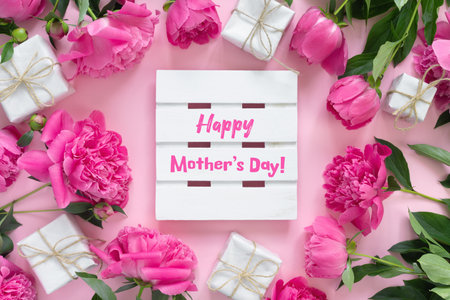 Bouquet of beautiful pink peonies with gift boxes in paper wrapping. Round frame of flowers. White...