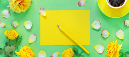Bouquet of beautiful yellow roses and cup of hot fresh aromatic coffee on green paper background....