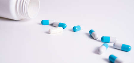 White and bleu medical pills on white background