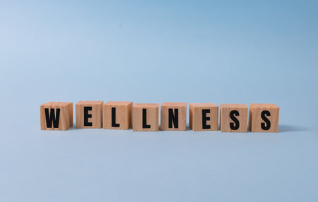 Wellness sign with wooden cubes on blue background.の写真素材