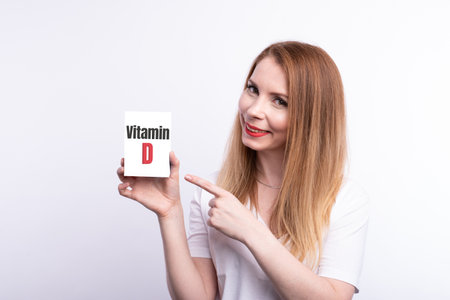 Vitamin D. Female hand shows a card with the inscription Vitamin D.の写真素材