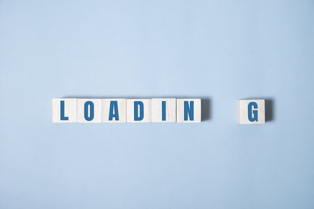 Wooden block cubes for LOADING wording on blue backgroundの写真素材