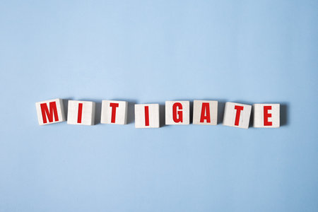 MITIGATE word made with building blocks on blue.の素材
