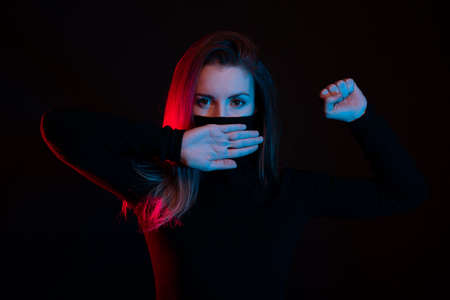 Female activist with a hand on her mouth, demonstrating violence on women. Woman protesting against domestic violence and abuseの写真素材