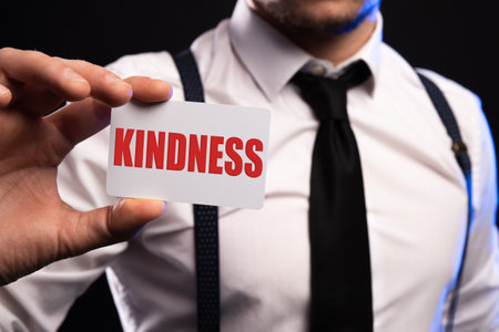 word kindness written on a white sheet of paper held by a man. High quality photoの写真素材