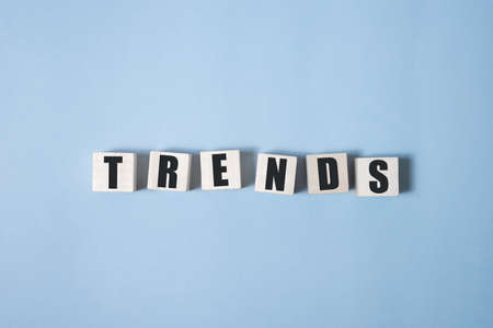 Trend word on cube blocks on white grey glossy background with reflectionの写真素材