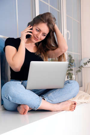 Girl sitting with crossed legs and working on laptop.