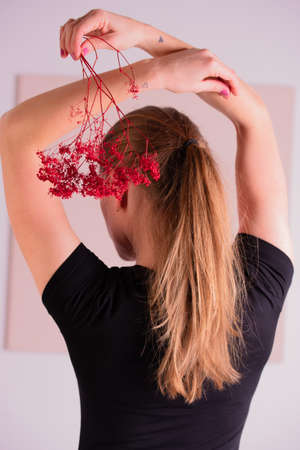 Back view of an elegant trendy hairstyle, interlacing curls and decorating with flower petals. Beautiful and well-groomed blonde hair.の写真素材