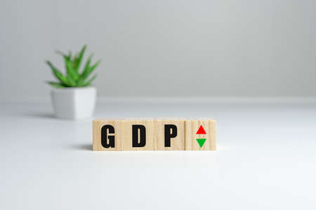 Hand is turning a dice and changes the direction of an arrow symbolizing that the GDP of a country is changing the trend and goes up instead of downの写真素材