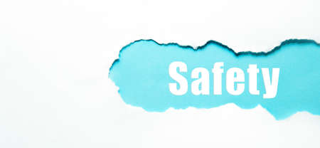 safety word under torn white paper on blue.の写真素材