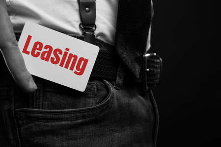 technology, internet, network, business concept - businessman hold a card with english word LEASINGの写真素材