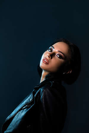 Beautiful stylish woman wearing black leather jacket. Fashionable and self-confident girl with long curly hair. Clothing, style and fashionの写真素材