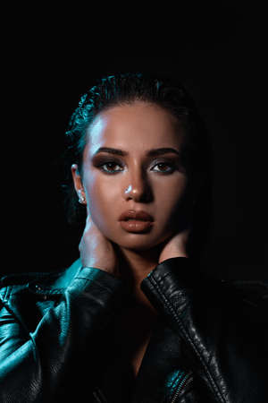 Beautiful stylish woman wearing black leather jacket. Fashionable and self-confident girl with long curly hair. Clothing, style and fashionの写真素材