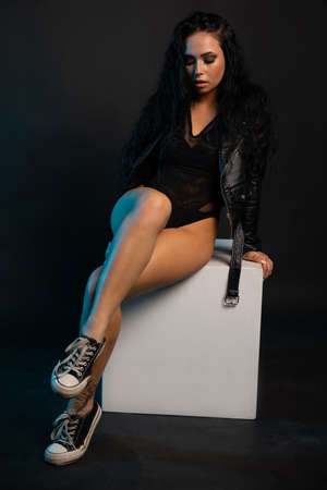 Beautiful stylish woman wearing black leather jacket. Fashionable and self-confident girl with long curly hair. Clothing, style and fashionの写真素材