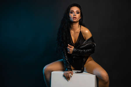 Beautiful stylish woman wearing black leather jacket. Fashionable and self-confident girl with long curly hair. Clothing, style and fashionの写真素材