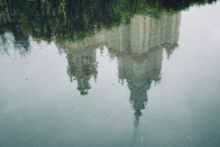 Reflection on the wet asphalt. Moscow State University. Aged photo. Toned effect. Spring Rainy day. Photo with retro filter.の写真素材