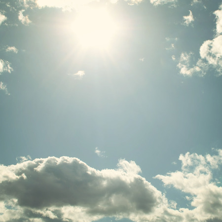 Sun above clouds - toned effect. Springtime sky - vintage photo. Sky with clouds and sun - retro filter.の写真素材