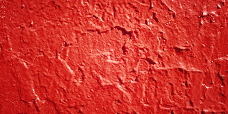 Concrete wall painted red. Close up for backdrop. Rough texture with aged effect. Street wall macro.の写真素材