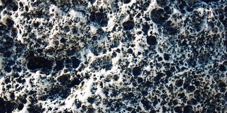 Magma background. Toned photo. Wide format. Porous rock texture. Black and white foamypumice. Foamy...