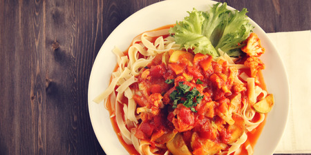 Ribbon pasta with Arrabiata sauce. Close up. Mediterranean dish. Tagliolini pasta with vegetables. Cauliflower, courgette and tomato stew. Italian cuisine. Vegan and vegetarian. Top view. Copy space.の写真素材