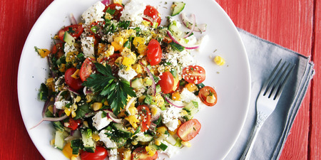 Colorful vegetable mix. Simple low calories salad. Cherry tomatoes, sweet corn, cucumber, bell pepper and cottage cheese. Weight loss dish. European cuisine. Top view.の写真素材