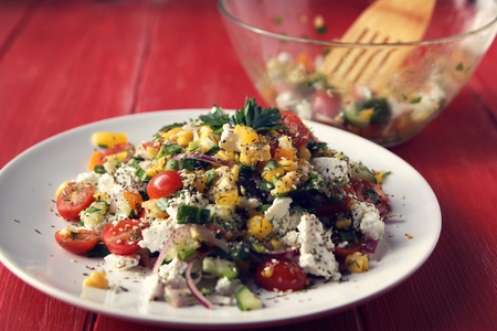 Colorful vegetable mix. Simple low calories salad. Cherry tomatoes, sweet corn, cucumber, bell pepper and cottage cheese. Weight loss dish. European cuisine.の写真素材