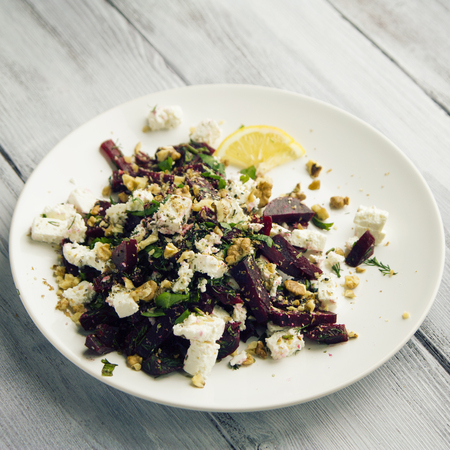 Beetroot salad with cottage cheese and walnuts. European cuisine. Organic food. Vegetarian appetizer. Simple side dish. Toned photo.の写真素材