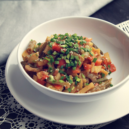 Vegetable stew with potato, carrot and green beans topped with sesame seeds. European cuisine. Healthy vegan lunch on the round white plate. European cuisine. Vegetarian. Toned image.の写真素材